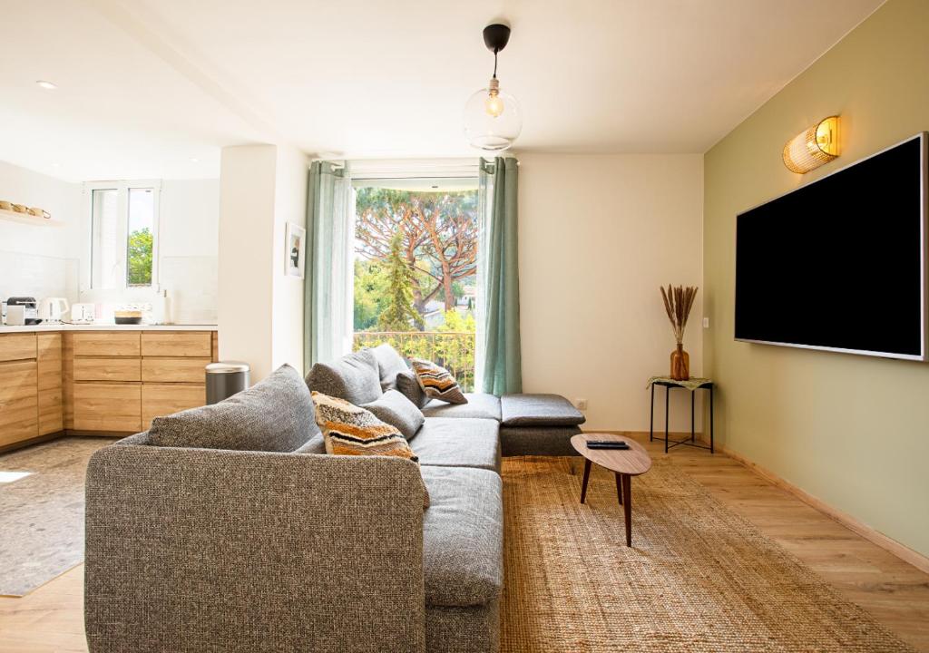 a living room with a couch and a flat screen tv at Magnifique 3 pièces - Proximité Place des Lices avec parking in Saint-Tropez