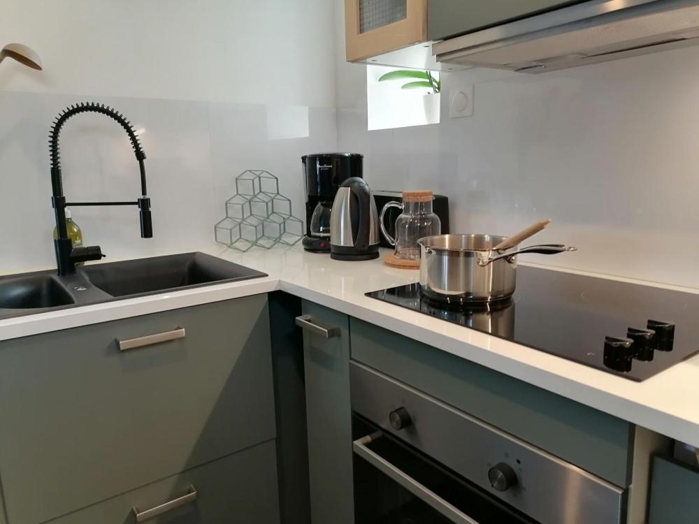 a kitchen with a sink and a stove top oven at Gîte LA Maison LA in Saint-Aubin-dʼAubigné