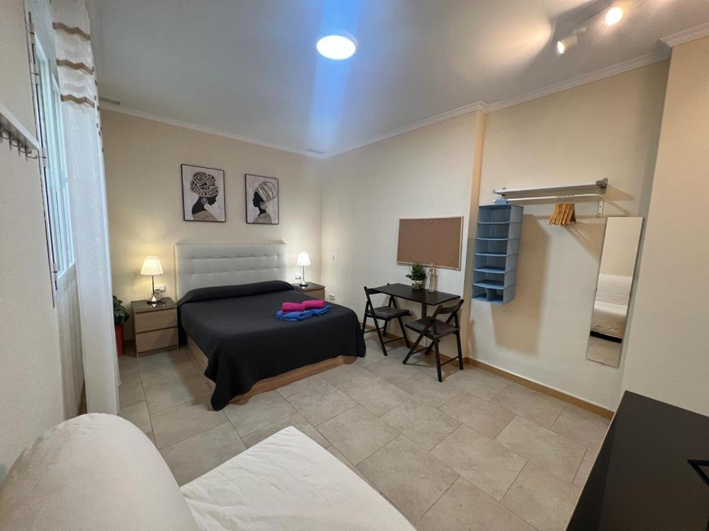 1 dormitorio con 1 cama y 1 mesa con lámpara en Rooms Barco, en Madrid