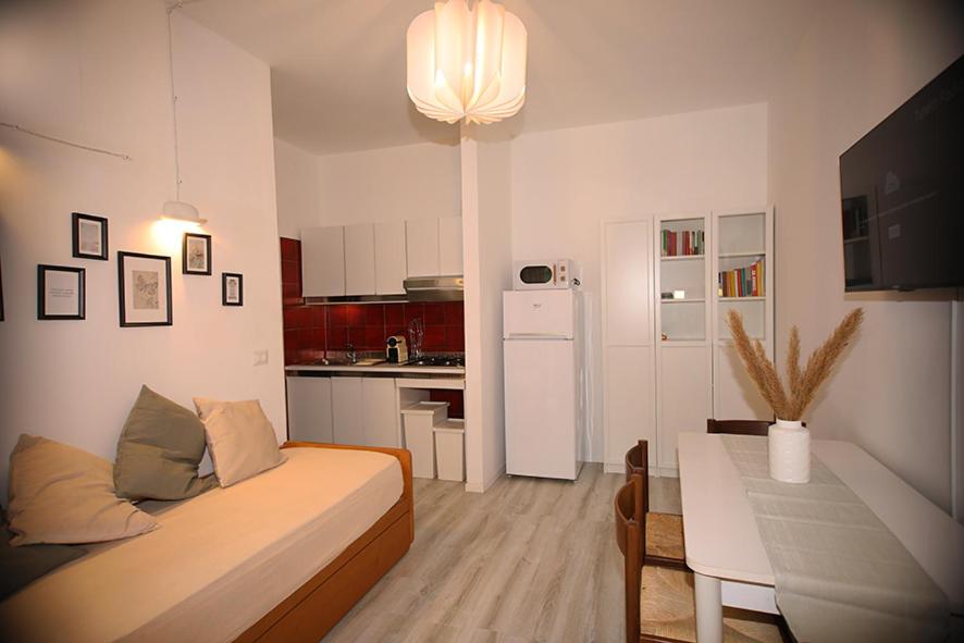 uma pequena sala de estar com uma cama e uma cozinha em BlancoHouse - Sul Parco em Riccione