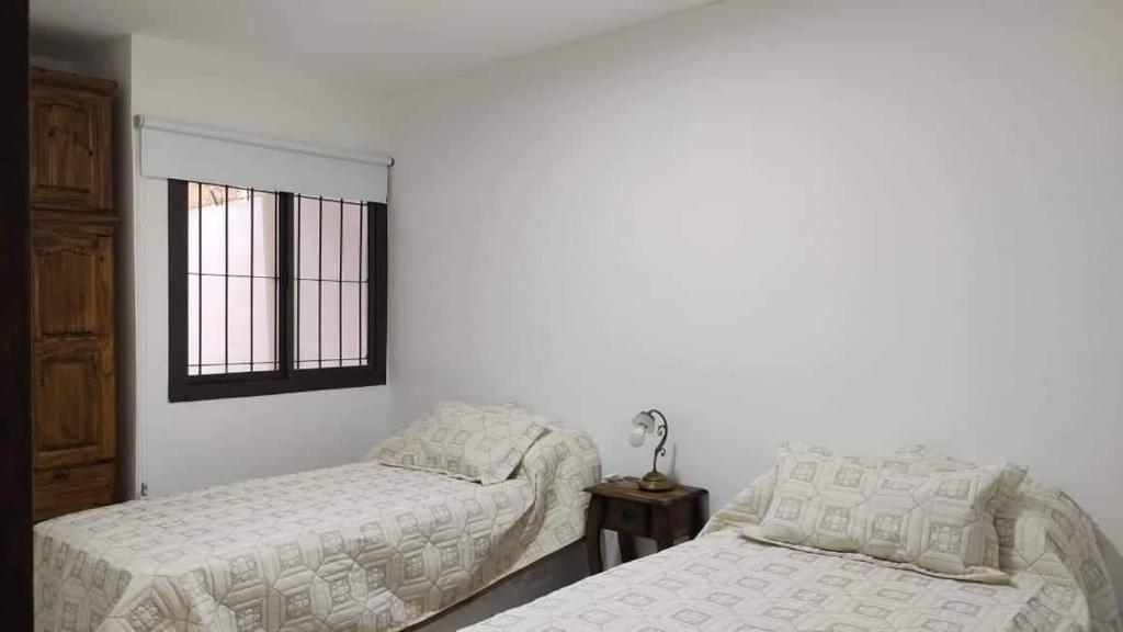 a bedroom with two beds and a window at Finde y Vacaciones in San Rafael