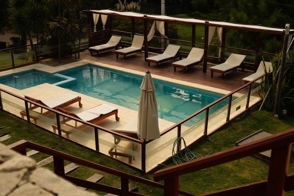 - une piscine avec des chaises et un parasol sur la terrasse dans l'établissement Arena de Mar Depto F, à Mar de las Pampas