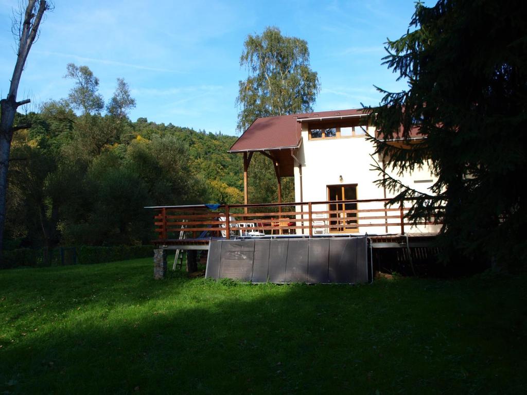 a house with a large deck in the grass at Chata u řeky in Zlenice 