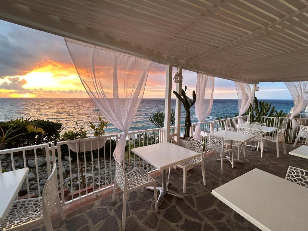 un restaurante con vistas al océano al atardecer en Mediterranean Boutique Hotel, en Tropea