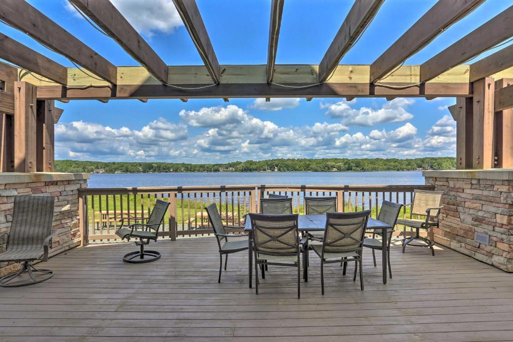 a deck with a table and chairs and a view of a lake at Hot Tub and Resort Amenities Pocono Lake Retreat! in Pocono Lake