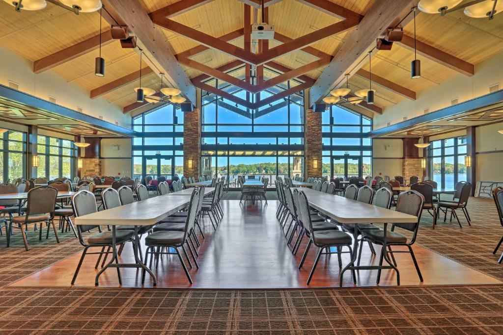 a dining hall with tables and chairs and windows at Hot Tub and Resort Amenities Pocono Lake Retreat! in Pocono Lake