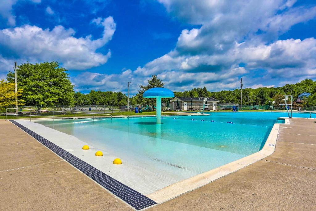 a large swimming pool with a blue umbrella in it at Hot Tub and Resort Amenities Pocono Lake Retreat! in Pocono Lake