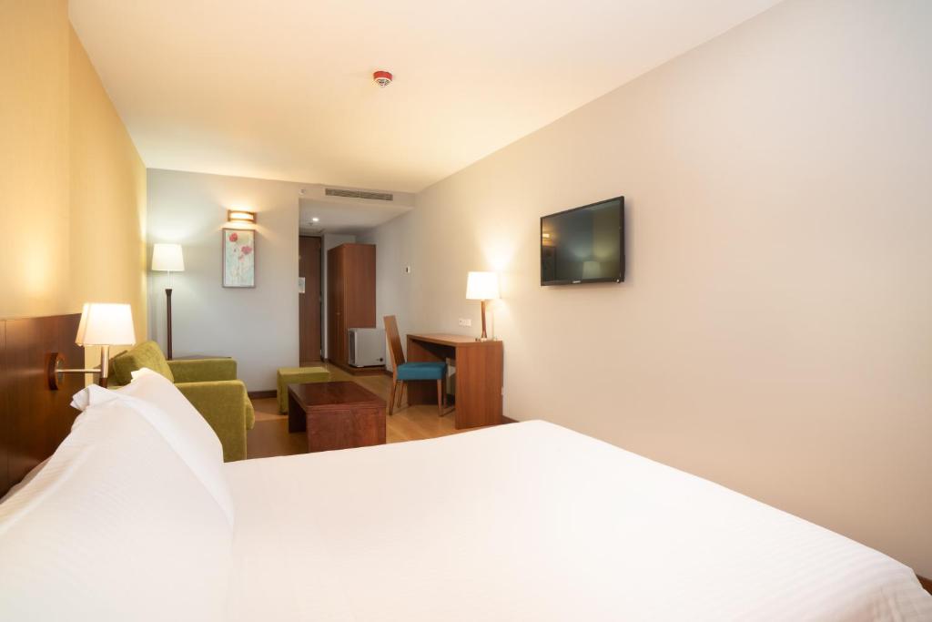 a hotel room with a bed and a living room at Hotel Habitel Select in Bogotá