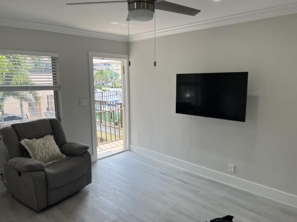 a living room with a chair and a flat screen tv at SEA ECHO APPARTMENT MOTEL in Fort Lauderdale