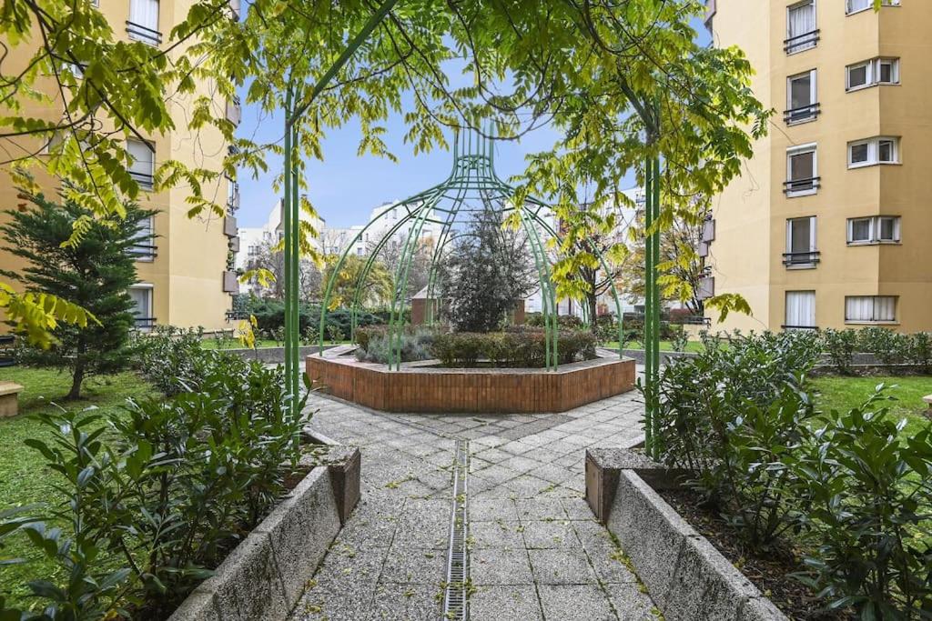 - un jardin avec une fontaine au milieu d'un bâtiment dans l'établissement "Joie de vivre" - Parisian Spacious & Charming flat, à Asnières-sur-Seine