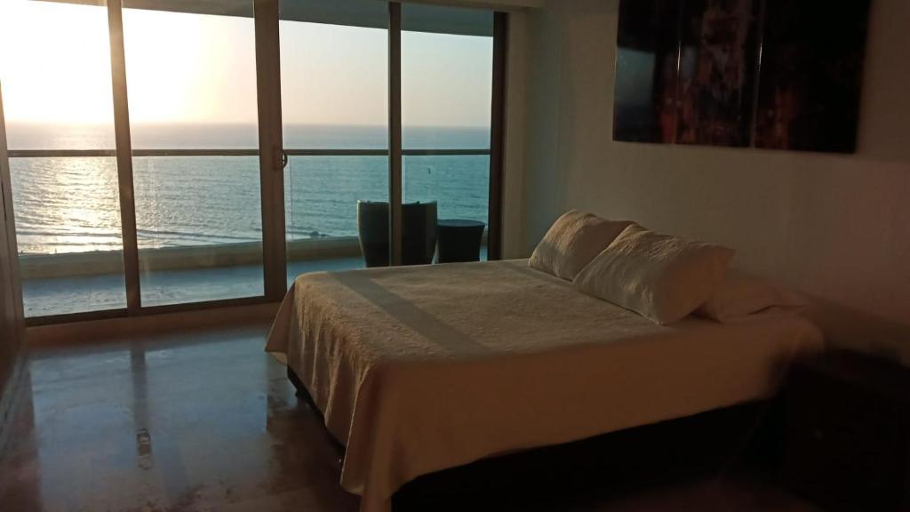 Luxury apartment in Morros - Cartagena de Indias في كارتاهينا دي اندياس: غرفة نوم مع سرير وإطلالة على المحيط