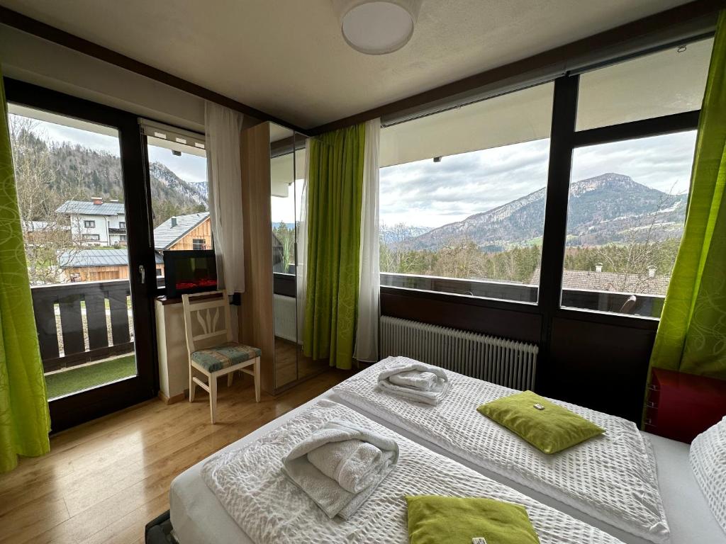 um quarto de hotel com duas camas e grandes janelas em Wohlfühlapartment Dachsteinblick em Bad Goisern