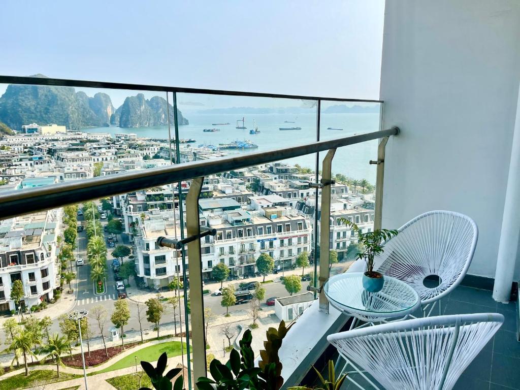 un balcone con tavolo, sedie e vista sulla città di Homestay Sapphire 4br Hạ Long View Biển a Ha Long