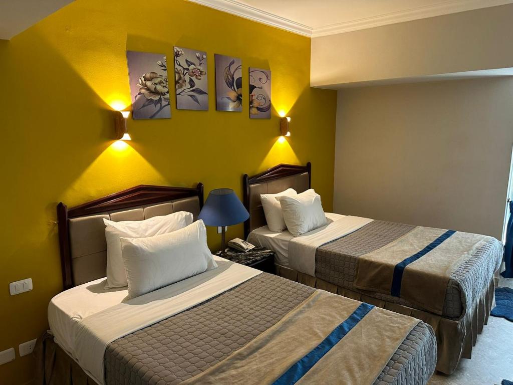 Postel nebo postele na pokoji v ubytování Gawharet Al Ahram Hotel