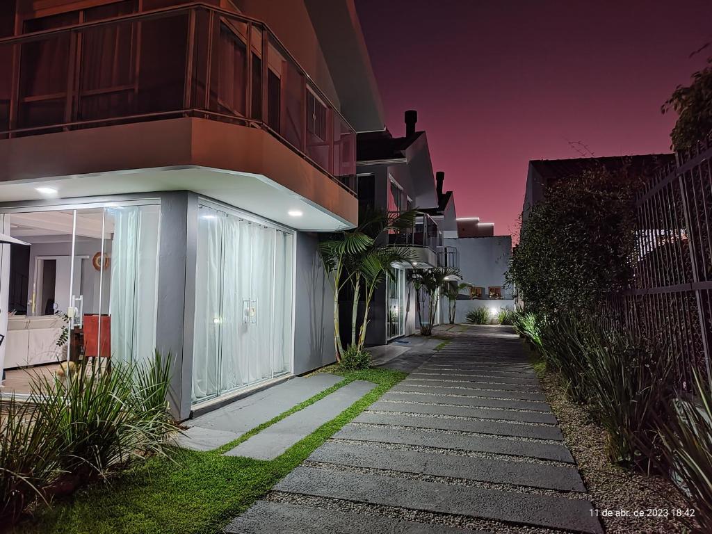 Una pasarela frente a un edificio por la noche en Residencial Bernardo 1 dormitório, en Florianópolis