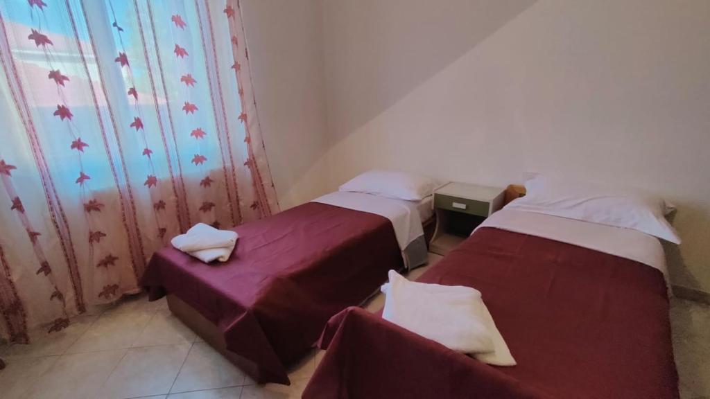 a room with two beds and a window at Angis AffittaCamere in Pero