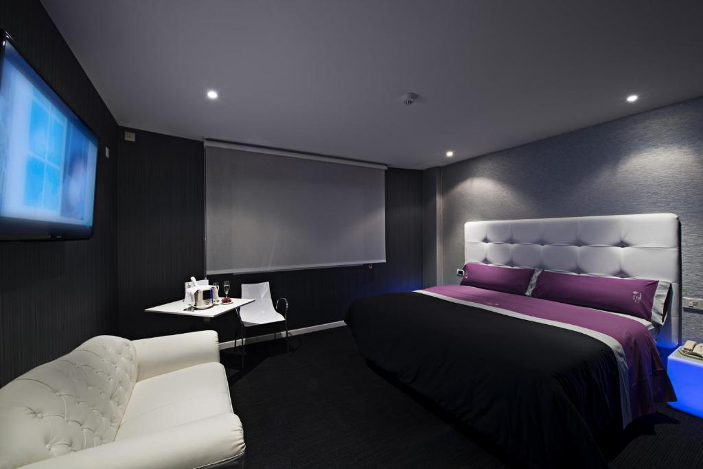 um quarto com uma cama grande e uma televisão em Motel Venus La Coruña em Guísamo