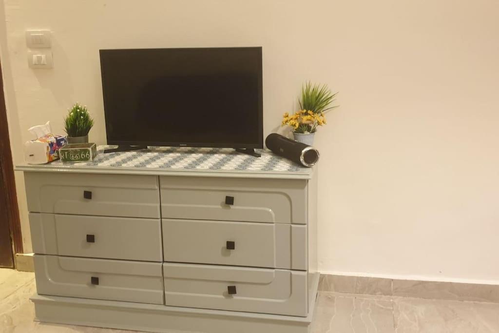 a dresser with a television on top of it at Newly renovated cozy studio 2 min 2 SEA in Alexandria