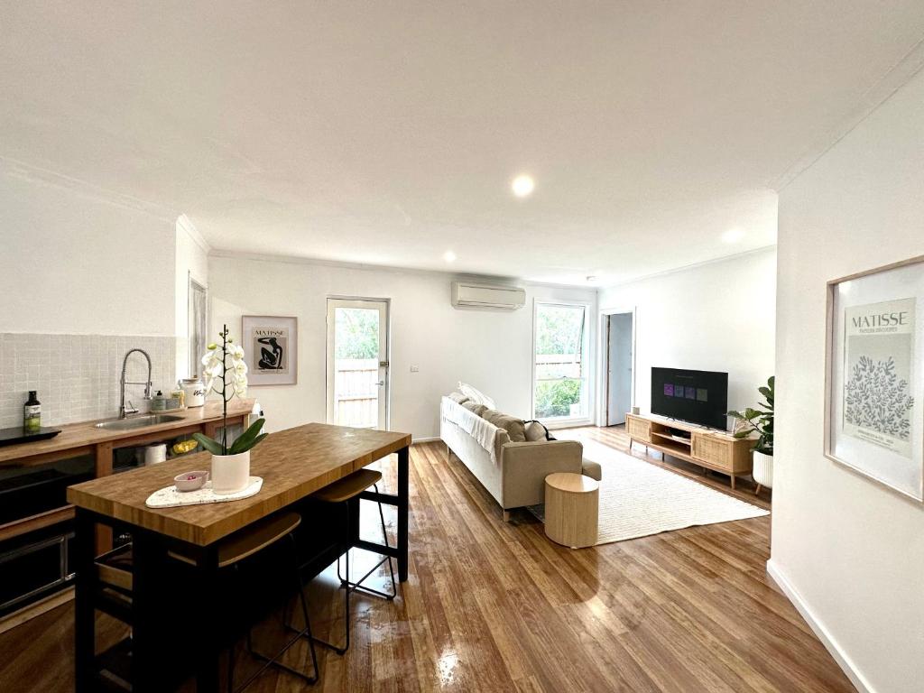 a kitchen and living room with a table and a couch at Guest house on the park in Burwood East