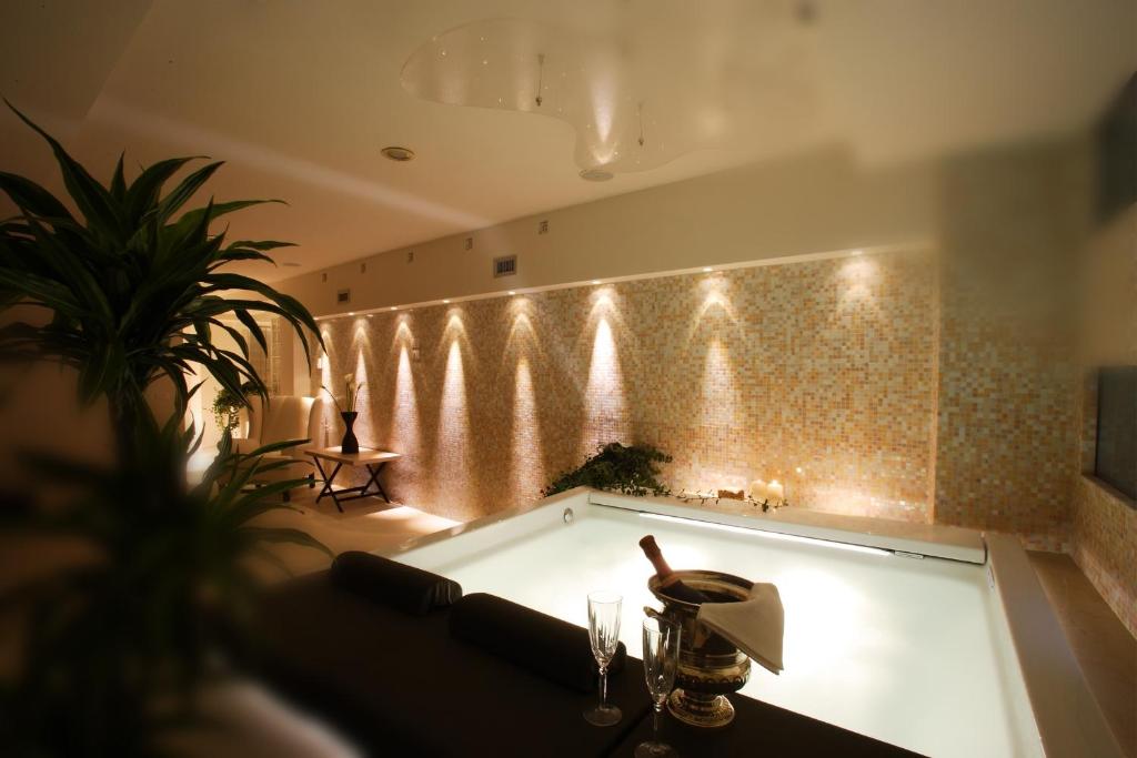 a bath tub in a room with a wall with lights at Ponte Vecchio Suites & Spa in Florence