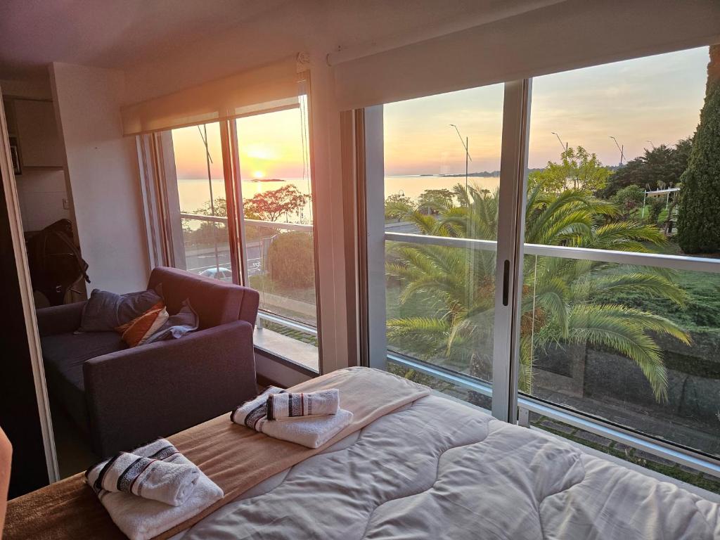 a bedroom with a bed and a view of the ocean at Rambla Sacramento - Paz frente al Río in Colonia del Sacramento