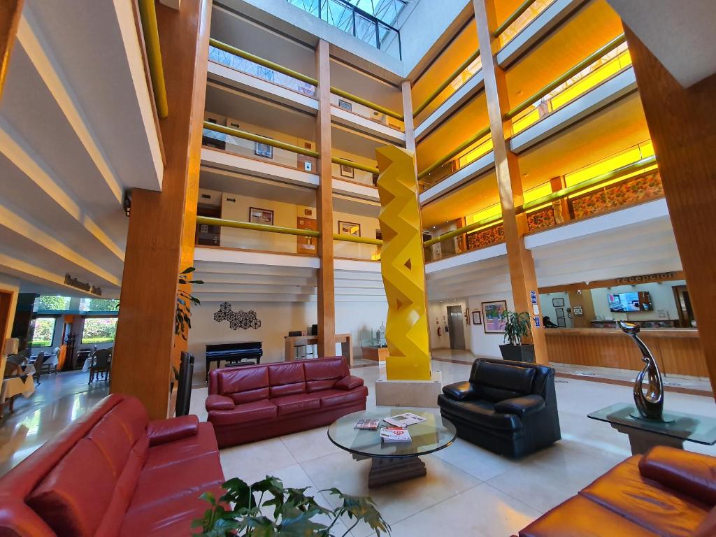 - un hall avec des canapés, des chaises et une table dans l'établissement Hotel Alcampo, à Querétaro