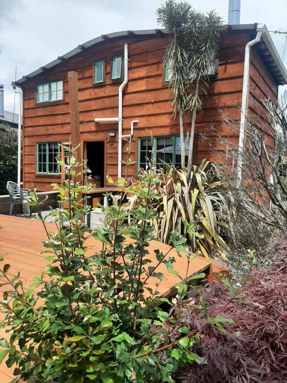 una cabaña de madera con un jardín frente a ella en Willowbrook, en Ohakune