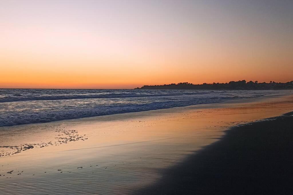 um pôr-do-sol numa praia com o oceano em Agradable casa al lado de la playa em Las Cruces