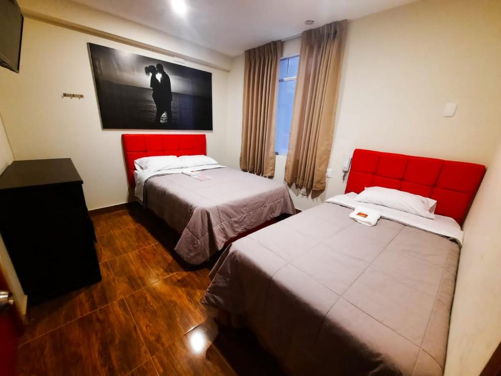 Habitación de hotel con 2 camas y una foto en la pared en Brianny Hotel en Churín