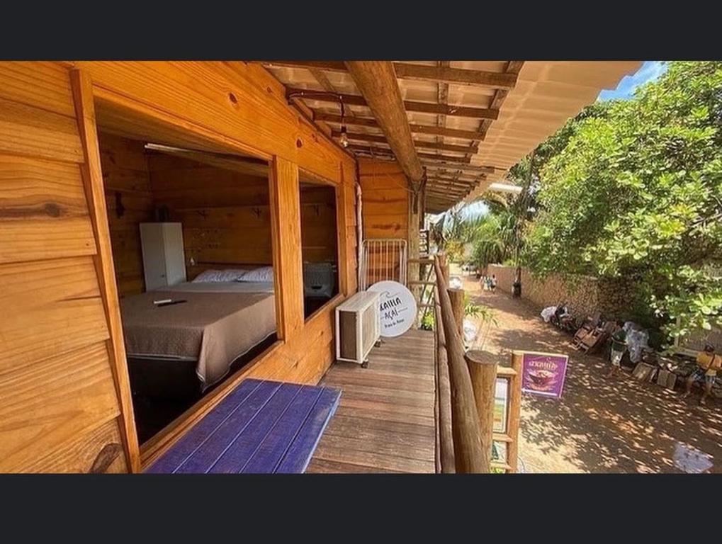 a wooden house with a bed and a balcony at Zicatela Beach Hostel in Pipa