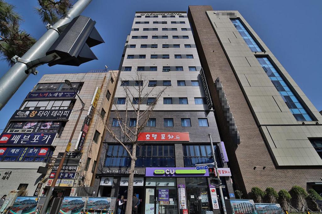 a tall building in the middle of a city at Hermes Hotel in Busan