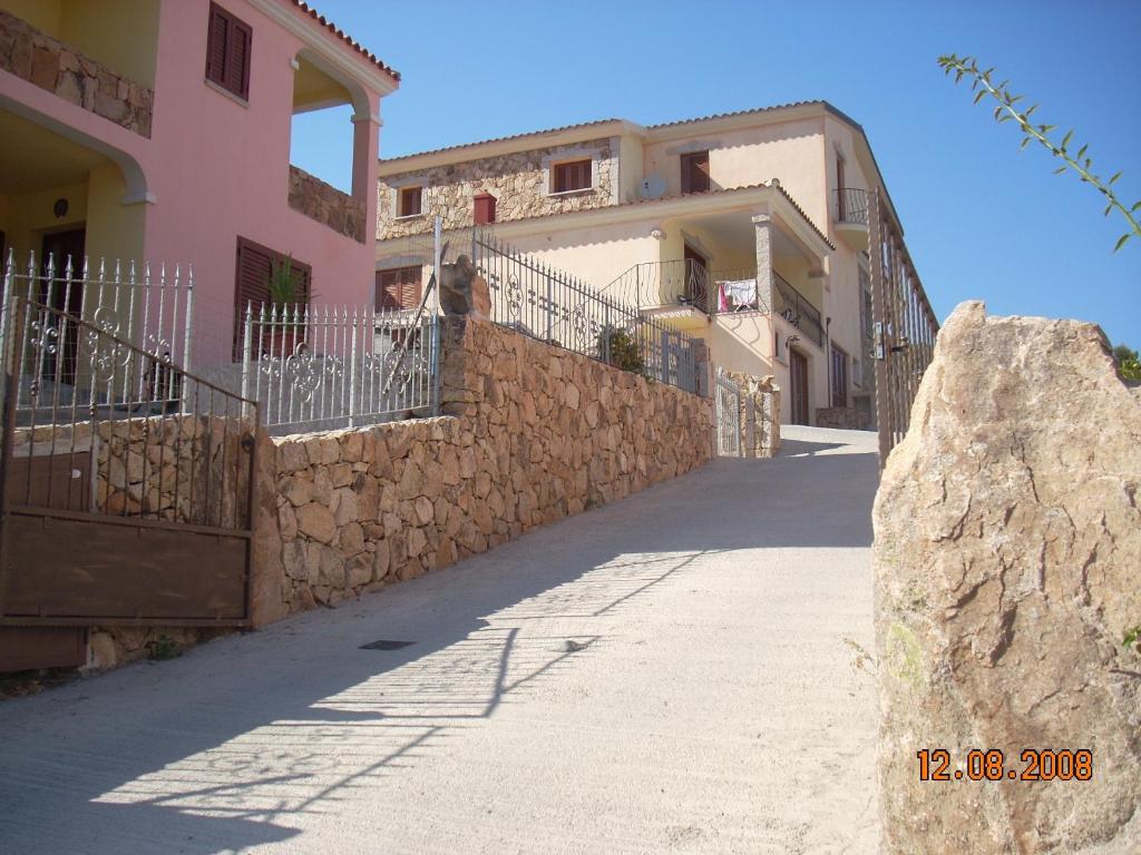 eine Straße vor einem Gebäude mit einer Steinmauer in der Unterkunft Dimora San Pietro in Budoni