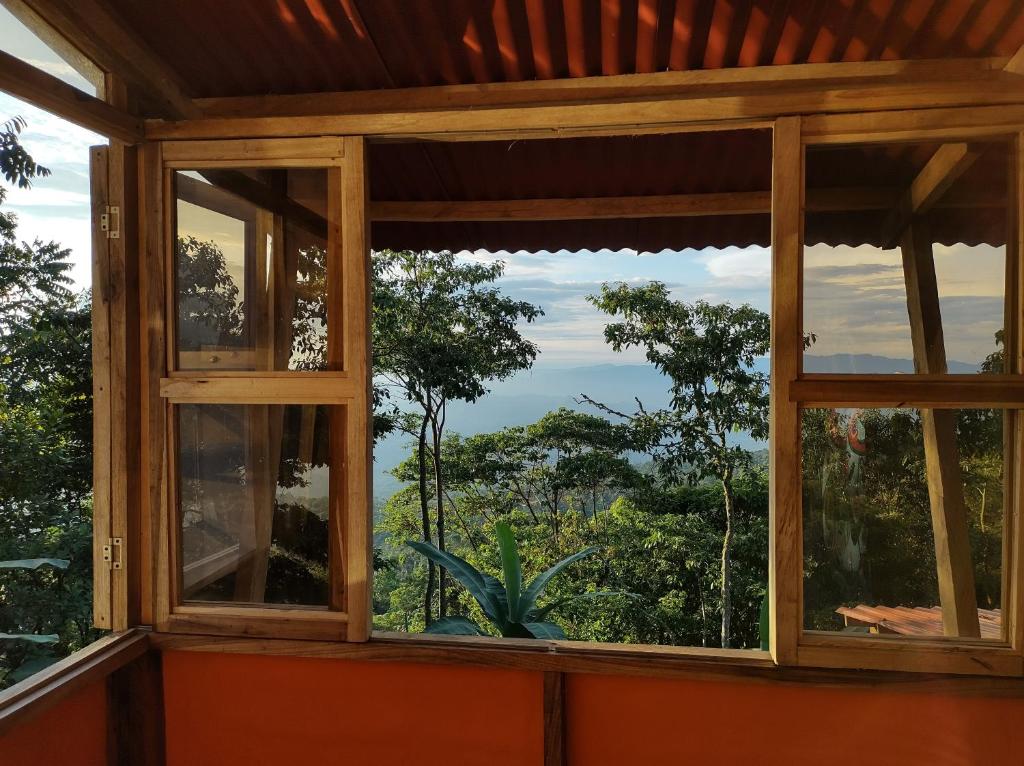 een raam in een huis met uitzicht op het bos bij Monte La MaMa Ecolodge in Viotá