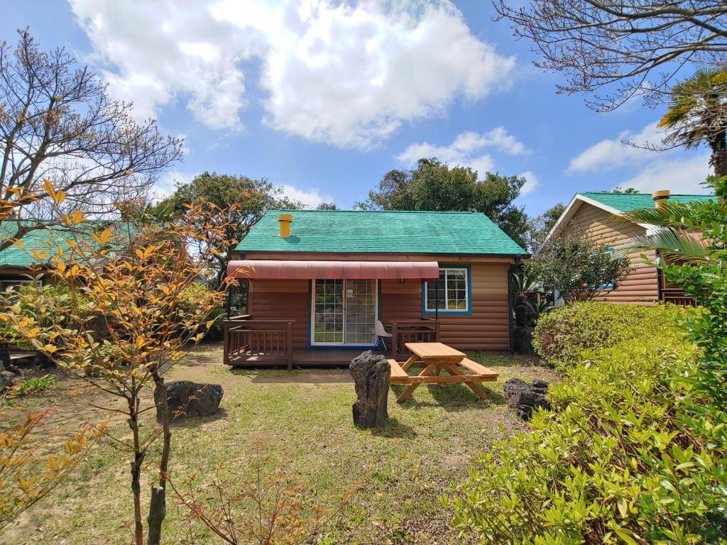 a cabin with a picnic table in front of it at Solbaram Punggyungsori Pension in Seogwipo