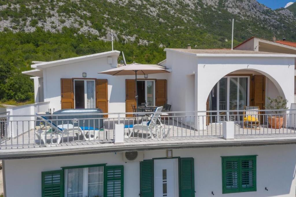 ZadvarjeにあるApartment Green Peaceの緑のシャッターとバルコニーのある大きな白い家