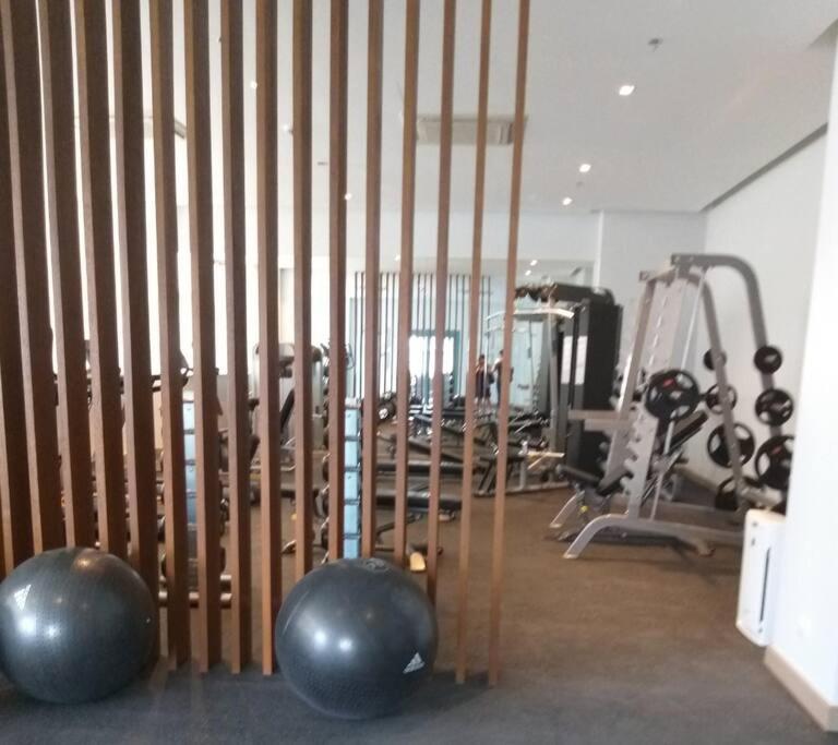 a gym with exercise balls and a treadmill at Cozy Studio Unit near Uptown Mall BGC in Manila