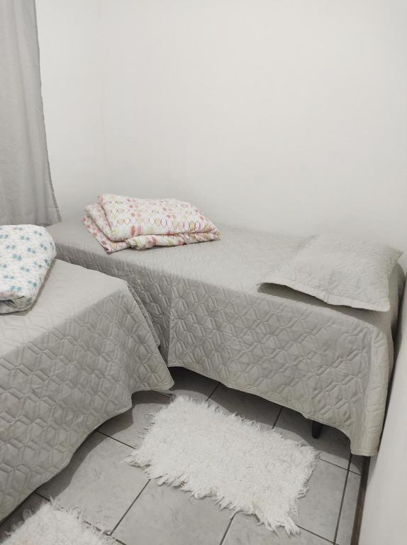 um sofá cinzento com almofadas e um tapete em Casa Penedo em Itatiaia