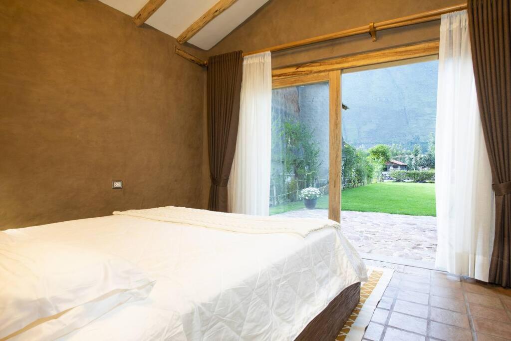 ein Schlafzimmer mit einem Bett und einem großen Fenster in der Unterkunft CASA REBEQ in Cusco