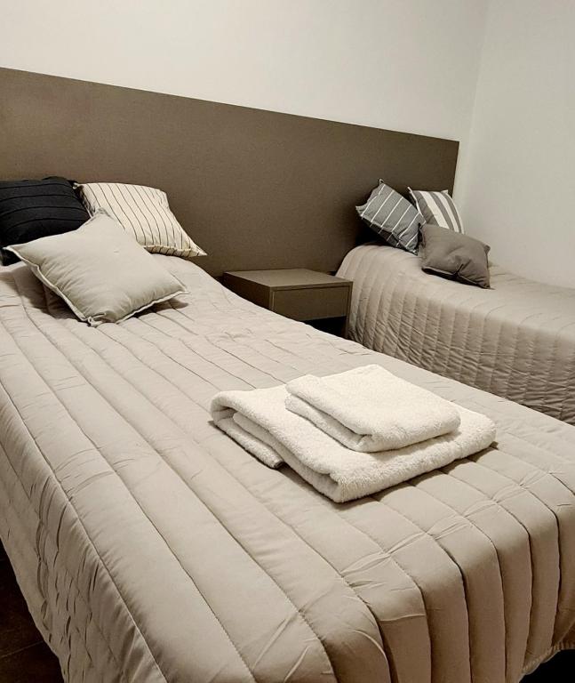 a bedroom with two beds with towels on them at Tres Marías Apart in Chilecito
