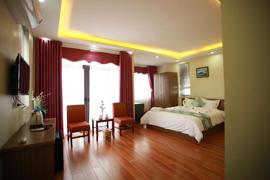 um quarto de hotel com uma cama e duas cadeiras em Family Airport Hotel - 5 minutes Noi Bai em Noi Bai