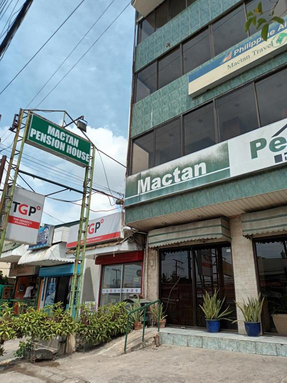 un edificio con una señal para un magritario en Mactan Pension House en Isla de Mactán