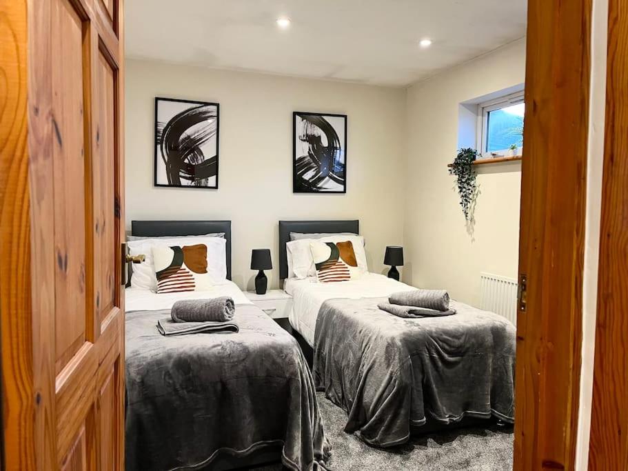 2 bedden in een kamer met 2 bedden, waarvan 1 tweepersoonsbed en 1 eenpersoonsbed. bij Central Semi - Detached Home with Private Parking! in Buckinghamshire