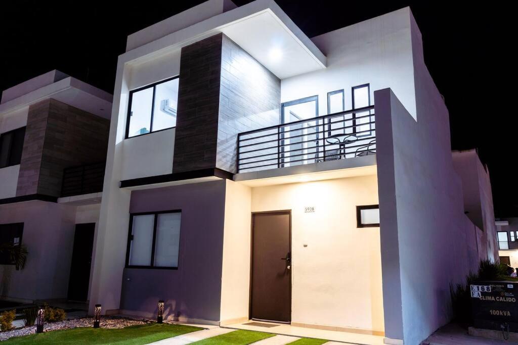 a white house with a front door at night at Hermosa y acogedora casa en comunidad privada in Mazatlán