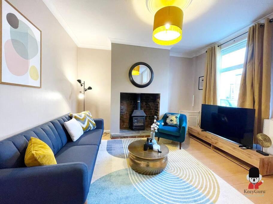 a living room with a blue couch and a tv at KozyGuru / 2BR 4 Beds / Modern Fully equipped House / Atherton Manchester / Close to Supermarket and Train Station / UMAT144 in Atherton
