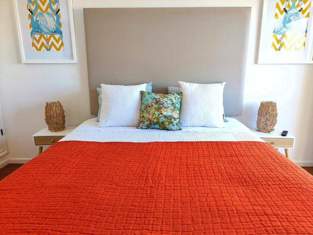 a bed with a red blanket and pillows on it at Aveiro House - City Center Rooms in Aveiro