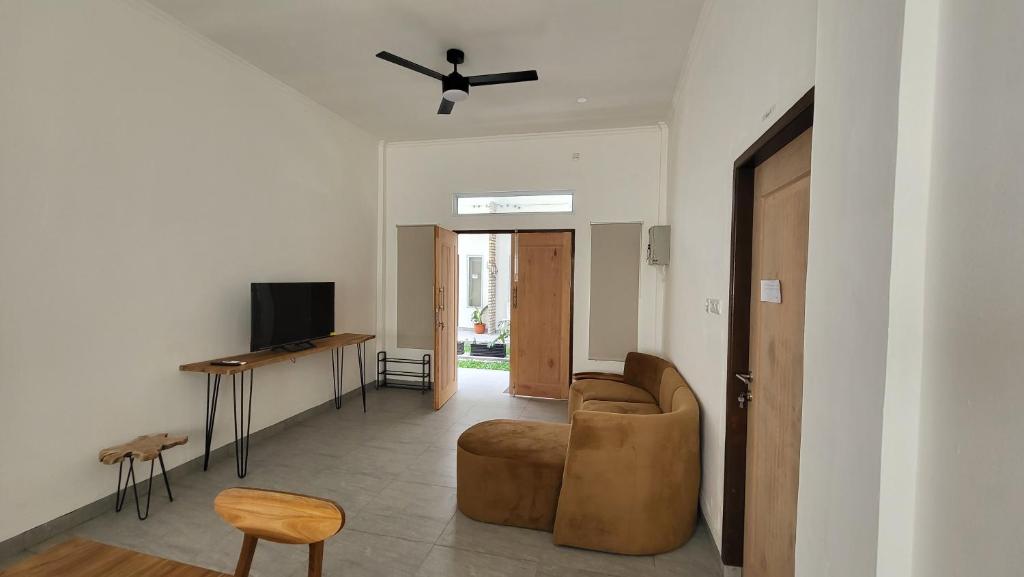 ein Wohnzimmer mit einem Sofa und einem Deckenventilator in der Unterkunft Rumah Tropis - Lantai 1 in Pekanbaru