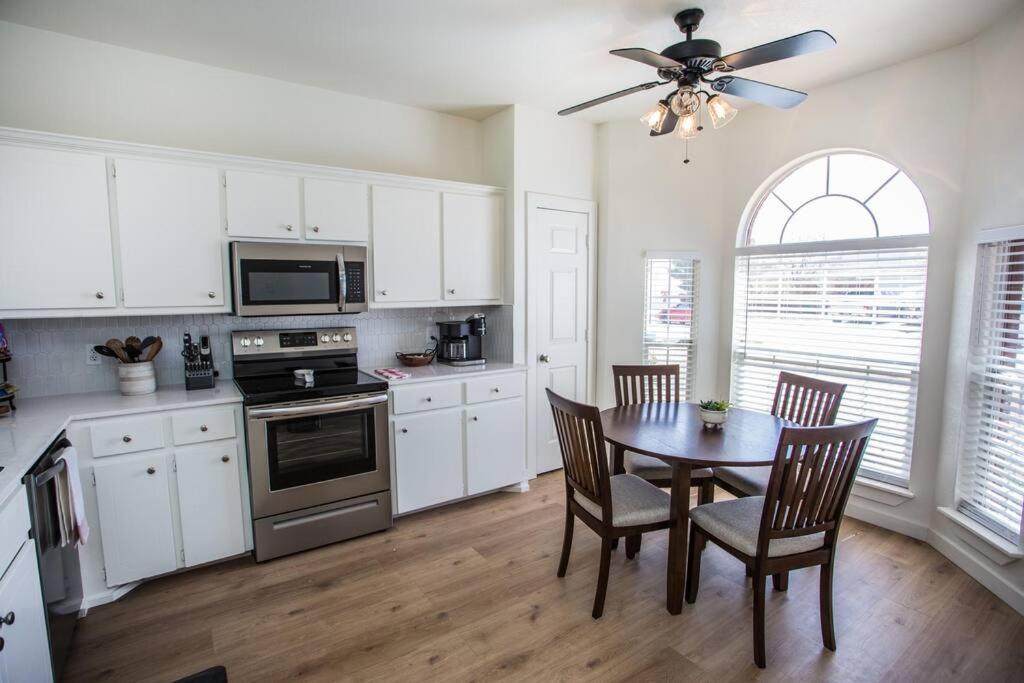 a kitchen with a table and chairs and a ceiling fan at 7 beds Relax by Texas Tech & Hospitals Sleeps 10 in Lubbock