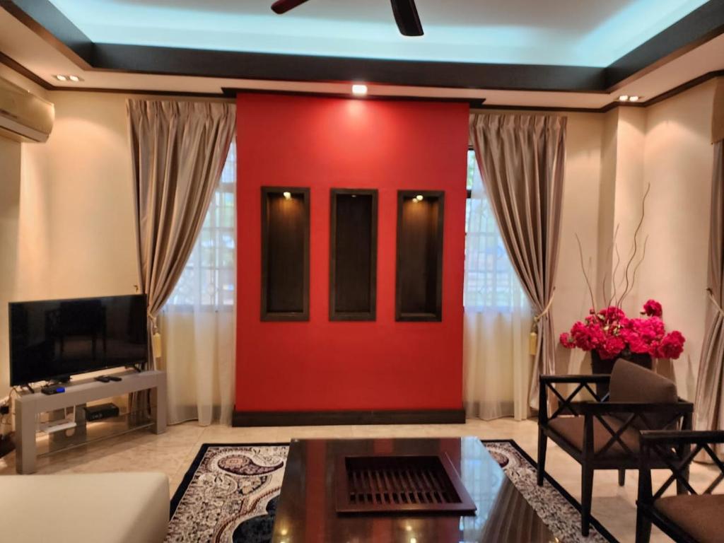a living room with a red wall at Mawar Singgah in Putrajaya