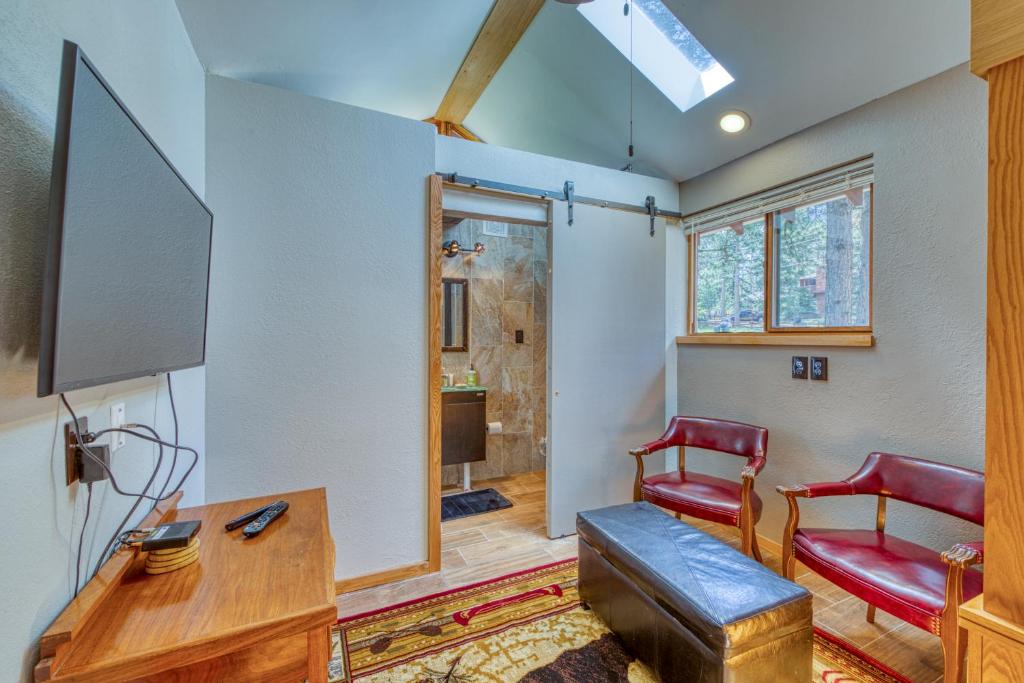 ein Wohnzimmer mit einem TV und roten Stühlen in der Unterkunft Little Bear Cabin in Woodland Park