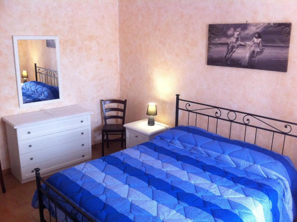 sypialnia z niebieskim łóżkiem, komodą i lustrem w obiekcie Il Terrazzino sul Duomo w mieście Orvieto